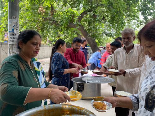 Volunteers serving food to people at a community meal