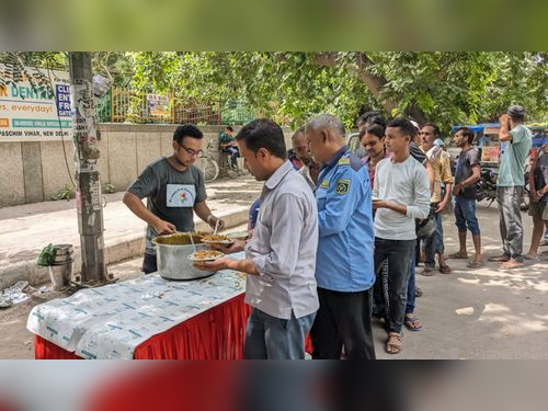 Volunteers serving freshly prepared meals at a community food distribution