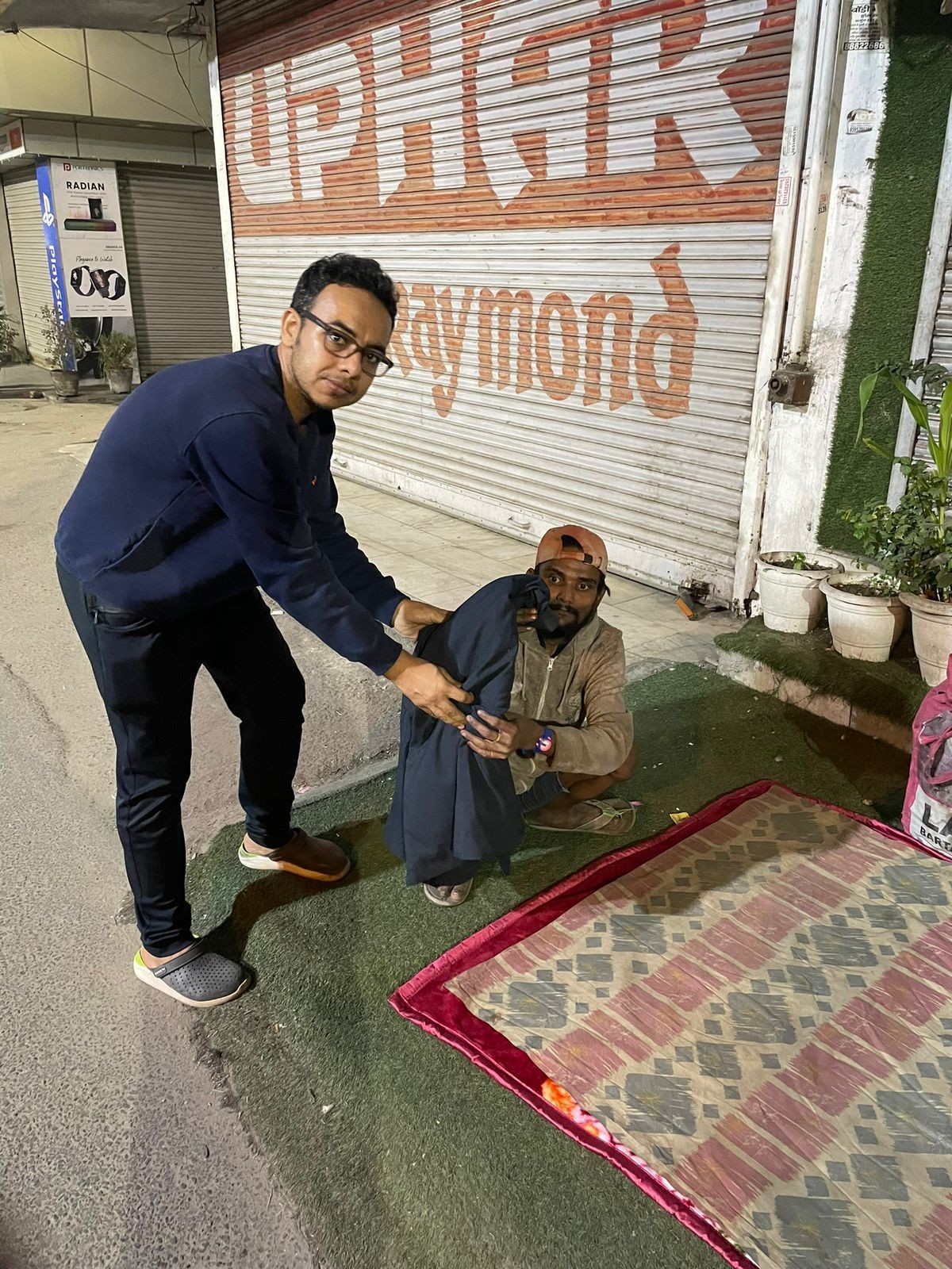 A volunteer handing clothes to a person in need
